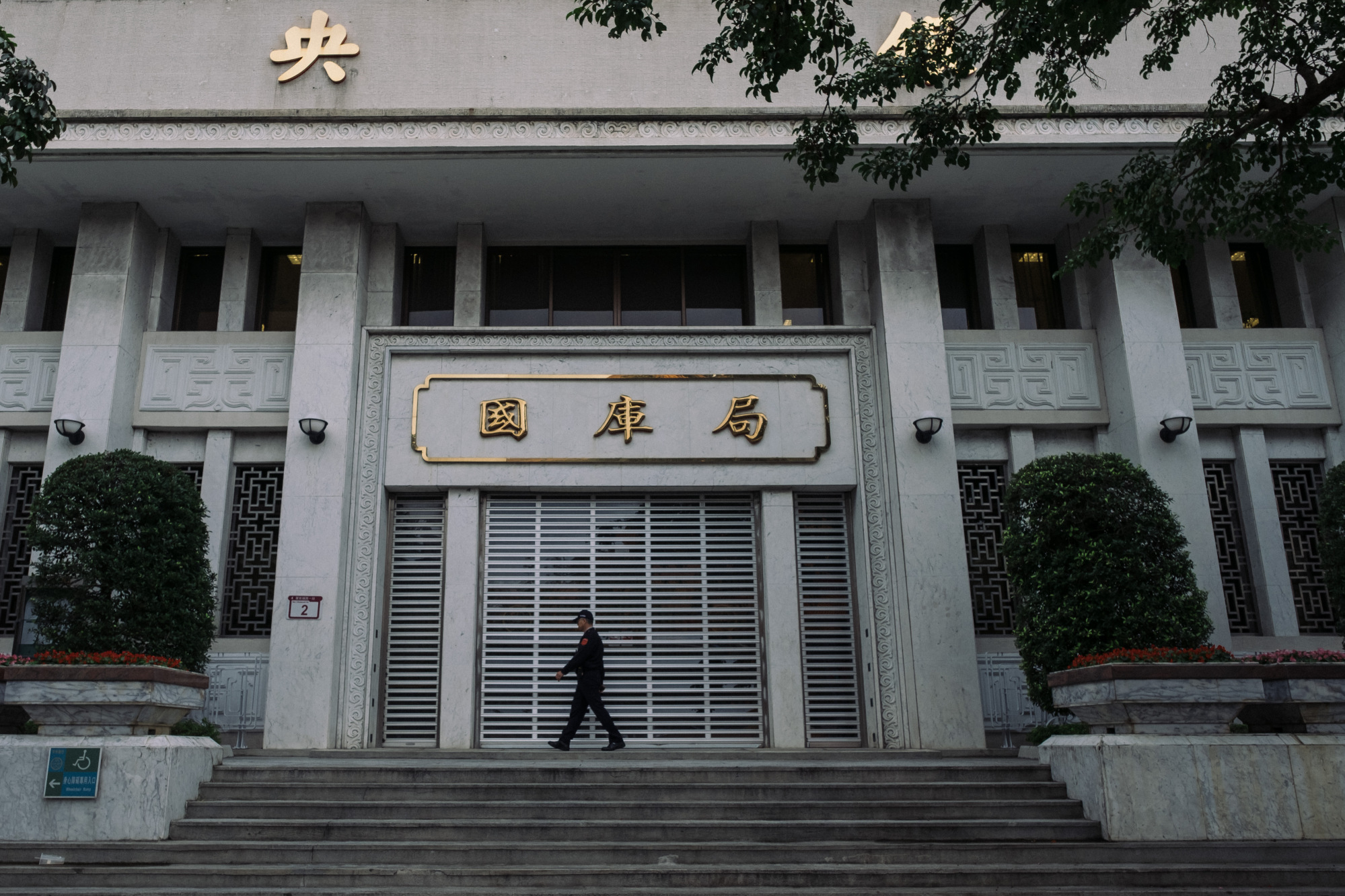 A security officer walks past signage for Department of the Treasury displayed at the Taiwan Central Bank headquarters building in Taipei, Taiwan, on Monday, Jan. 22, 2018. Taiwanese President Tsai Ing-wen favors choosing monetary policy maker Yang Chin-long to become the next chief of Taiwan's central bank, according to a person familiar with the matter.