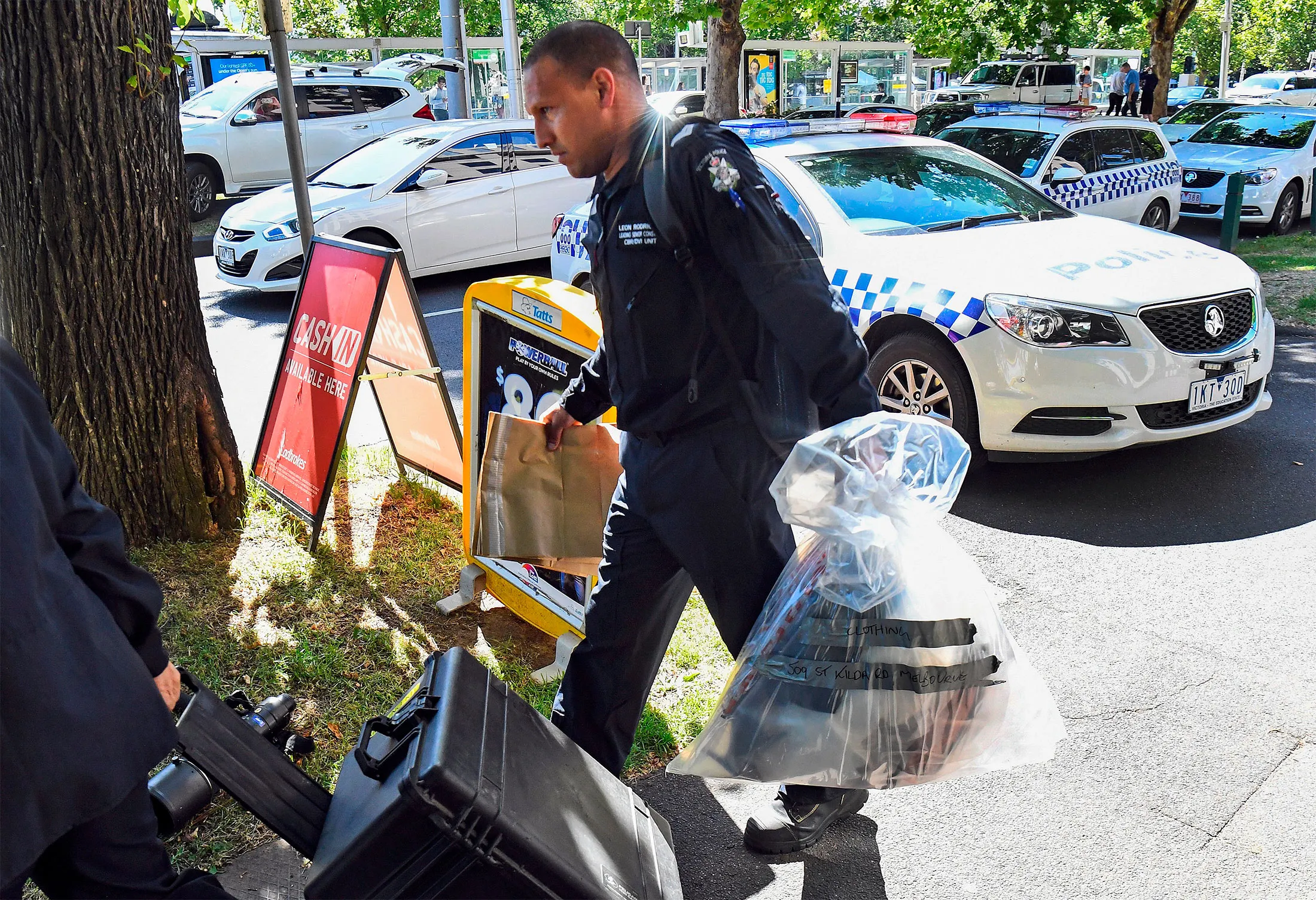 A Victoria Police forensic officer carries items to be loaded into a trailer outside the Italian consulate in Melbourne on Jan. 9.