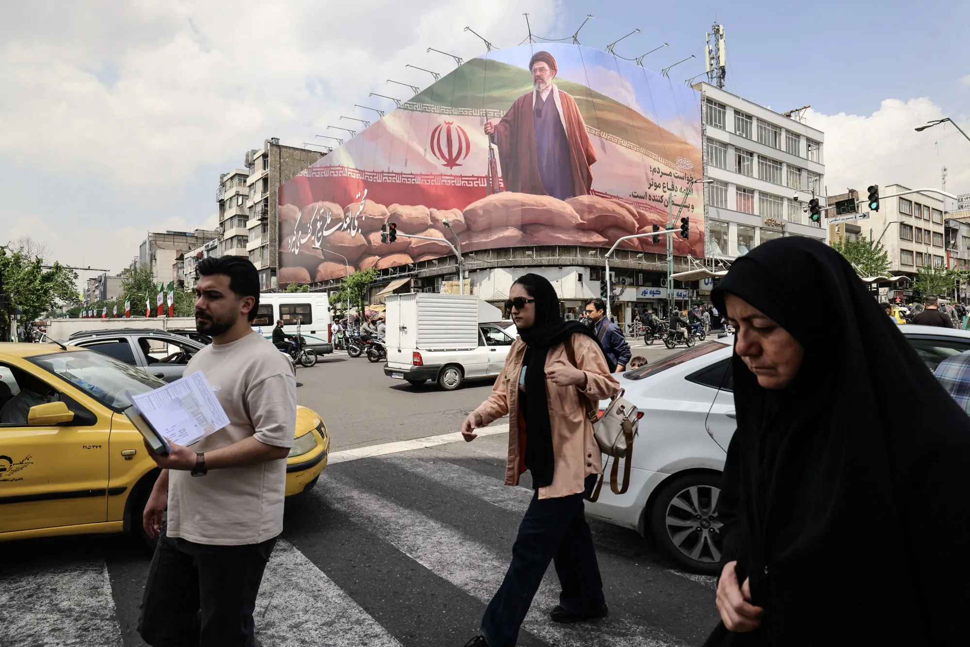 Iranians walk past a billboard depicting Supreme Leader Ayatollah Mojtaba Khamenei in Tehran.