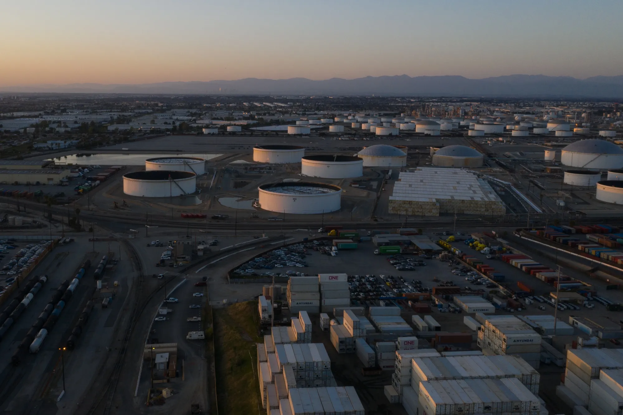 Oil storage tanks are seen at dusk at the Kinder Morgan Inc. fuel terminal in Wilmington, California.