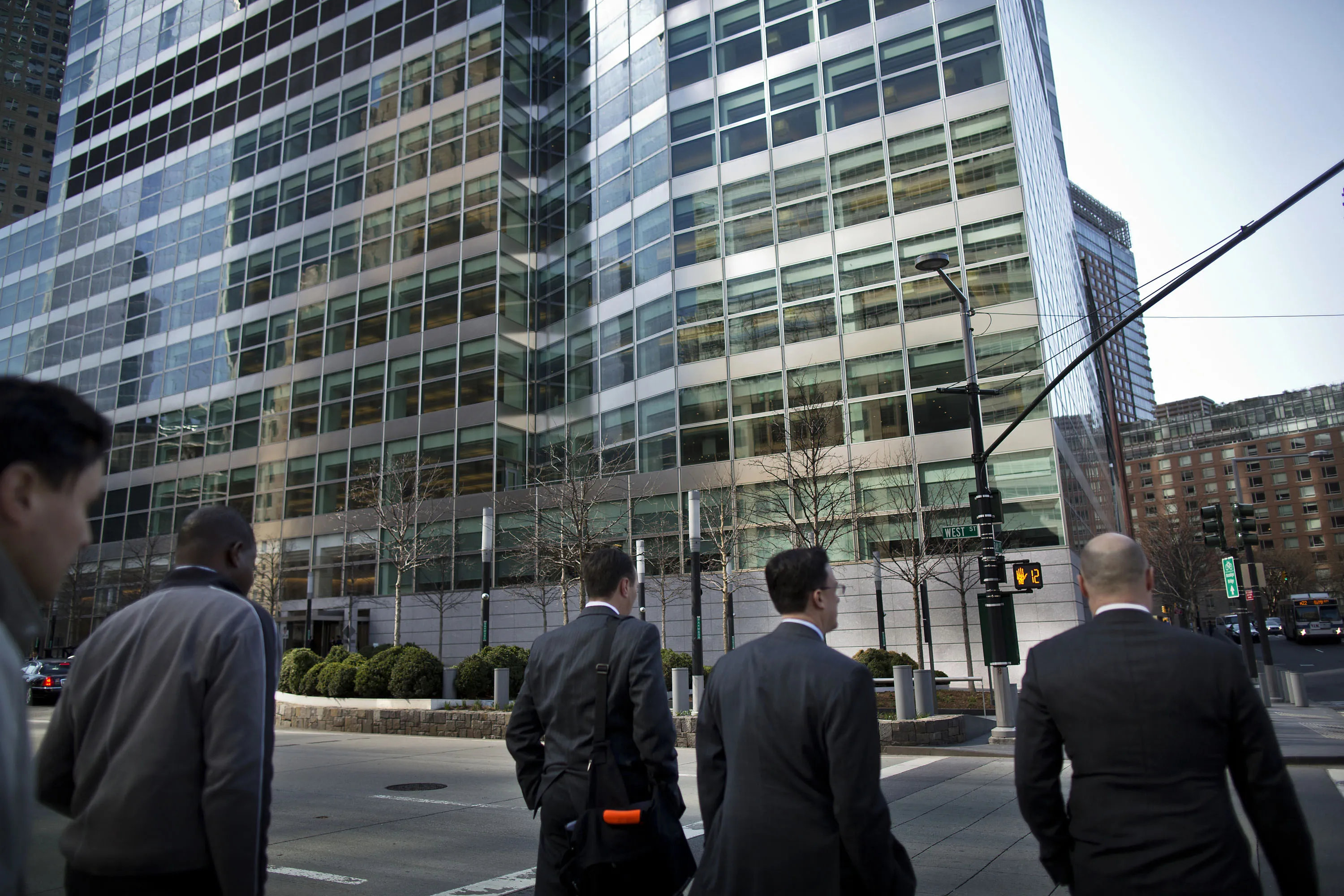 Men cross the street in front of Goldman Sachs Group Inc.'s headquarters in New York.