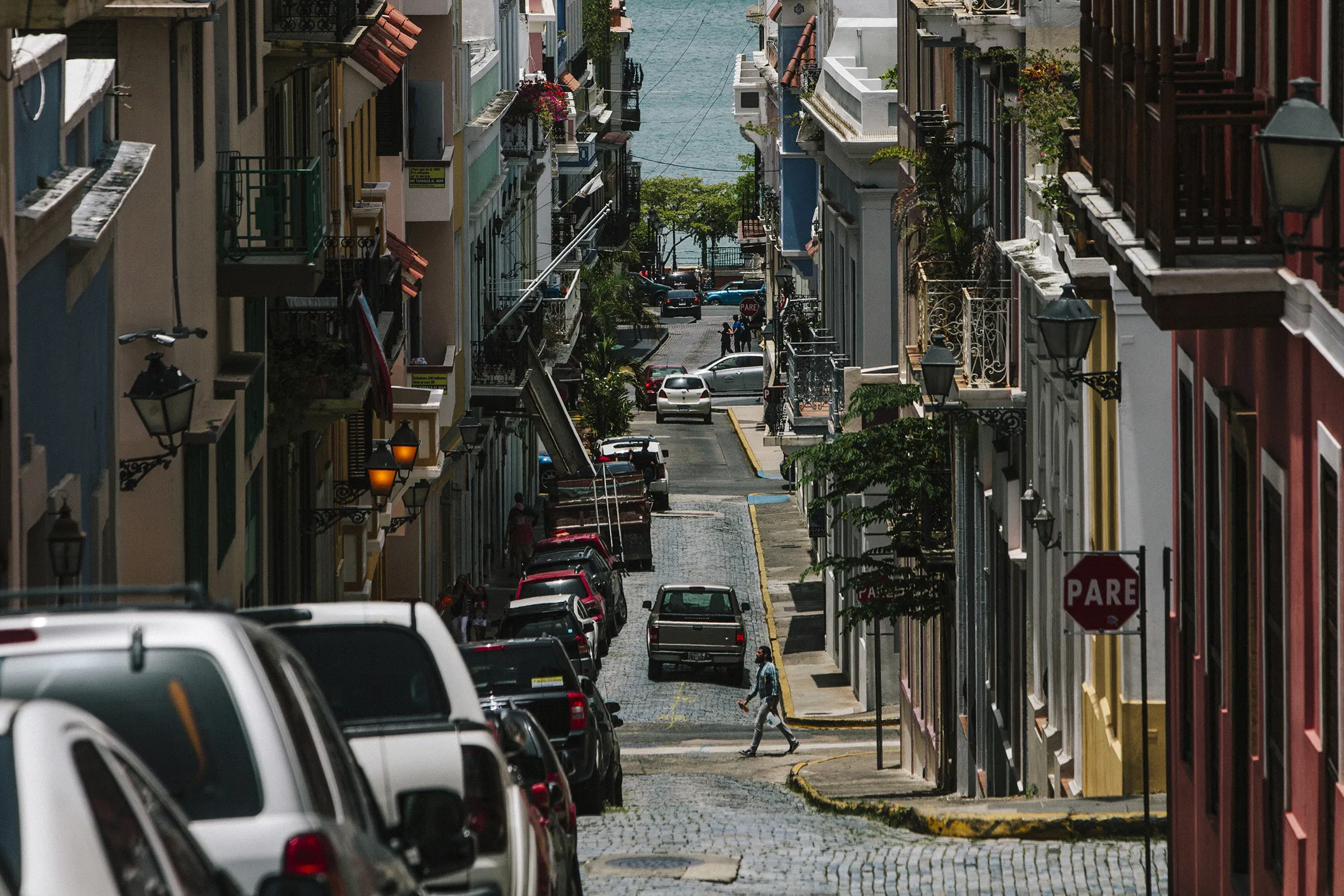 Cars sit parked along a street in the Old City of San Juan, Puerto Rico.