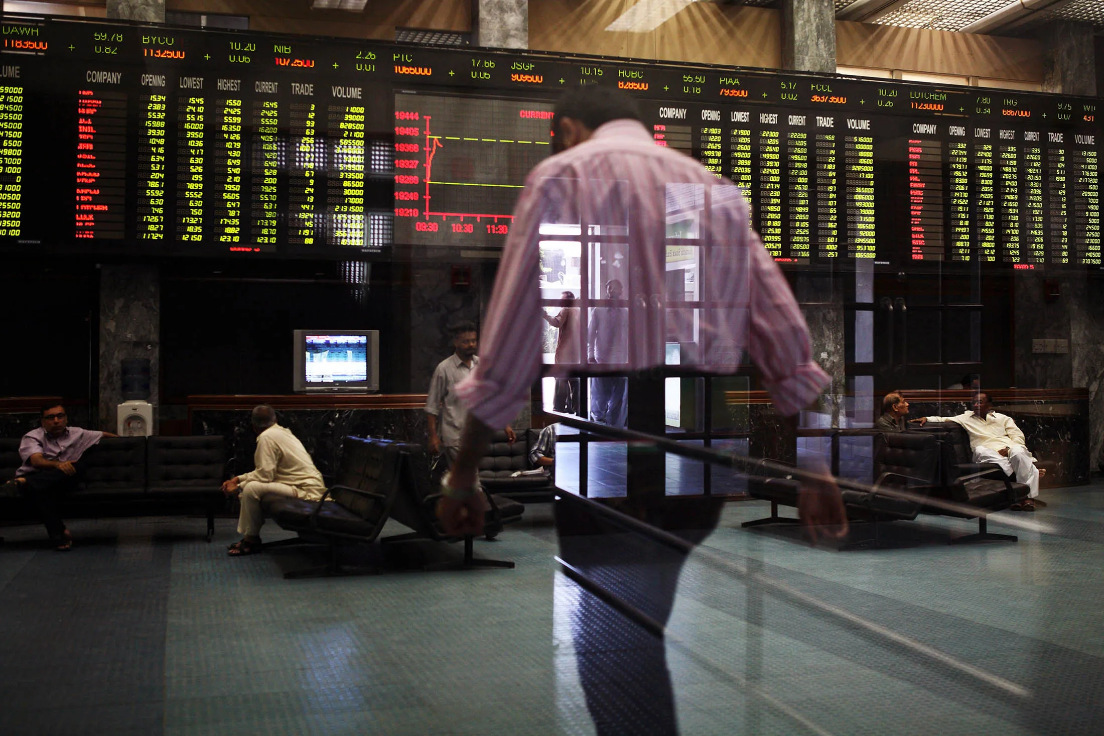 A trader is reflected against the trading hall of the Karachi Stock Exchange in Karachi, Pakistan, on Wednesday 08 May, 2013. Pakistan is to hold parliamentary elections on May 11, according to opinion polls Nawaz Sharif of the Pakistan Muslim League-N (PMLN) leads Imran Khan of Pakistan Tehrik-e-Insaf (PTI) to replace Asif Ali Zadari and become Pakistan's 12th President.
