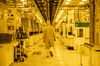 An employee wearing a cleanroom suit walks through the thin film bay inside the GlobalFoundries semiconductor manufacturing facility in Malta, New York, U.S., on Tuesday, March 16, 2021. Production plants for semiconductors have become a focal point as the economic recovery from the pandemic is held back in areas by a shortage of some of the critical electronic components necessary.