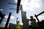 Construction workers lift a steel beam on a residential site in London.