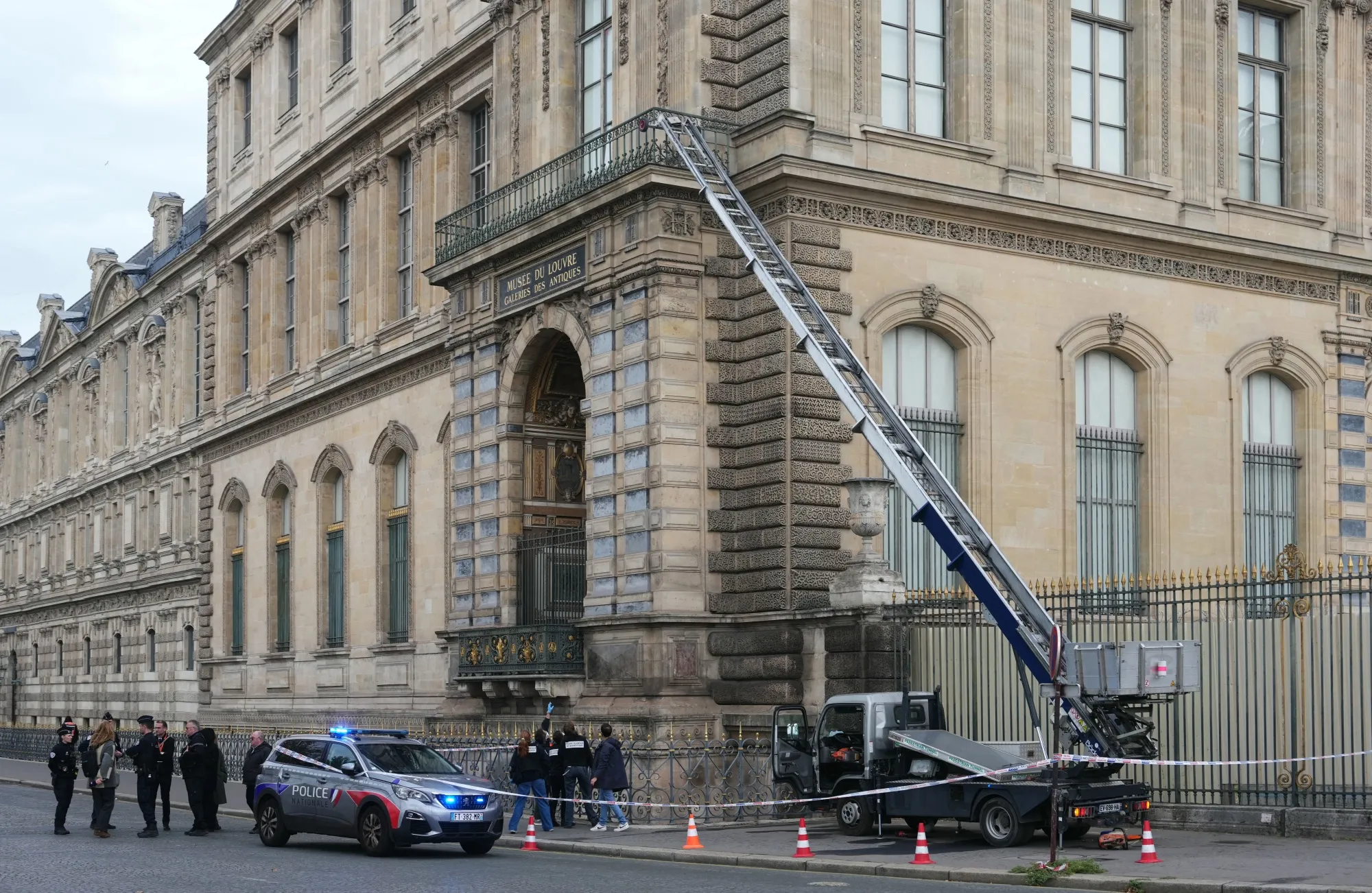 French police officers stand next to a furniture elevator used by robbers to enter the Louvre Museum in Paris on October 19, 2025.&nbsp;