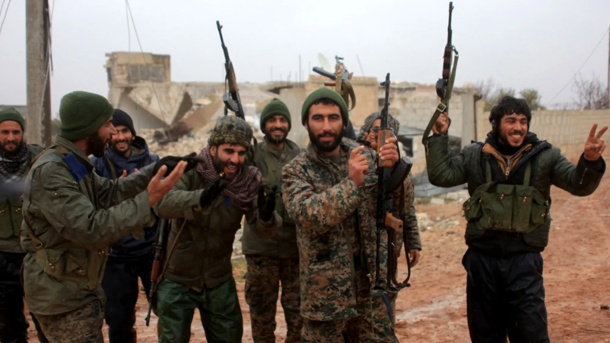 Syrian government soldiers celebrate after taking control of the village of Ratian, north of the embattled city of Aleppo.
