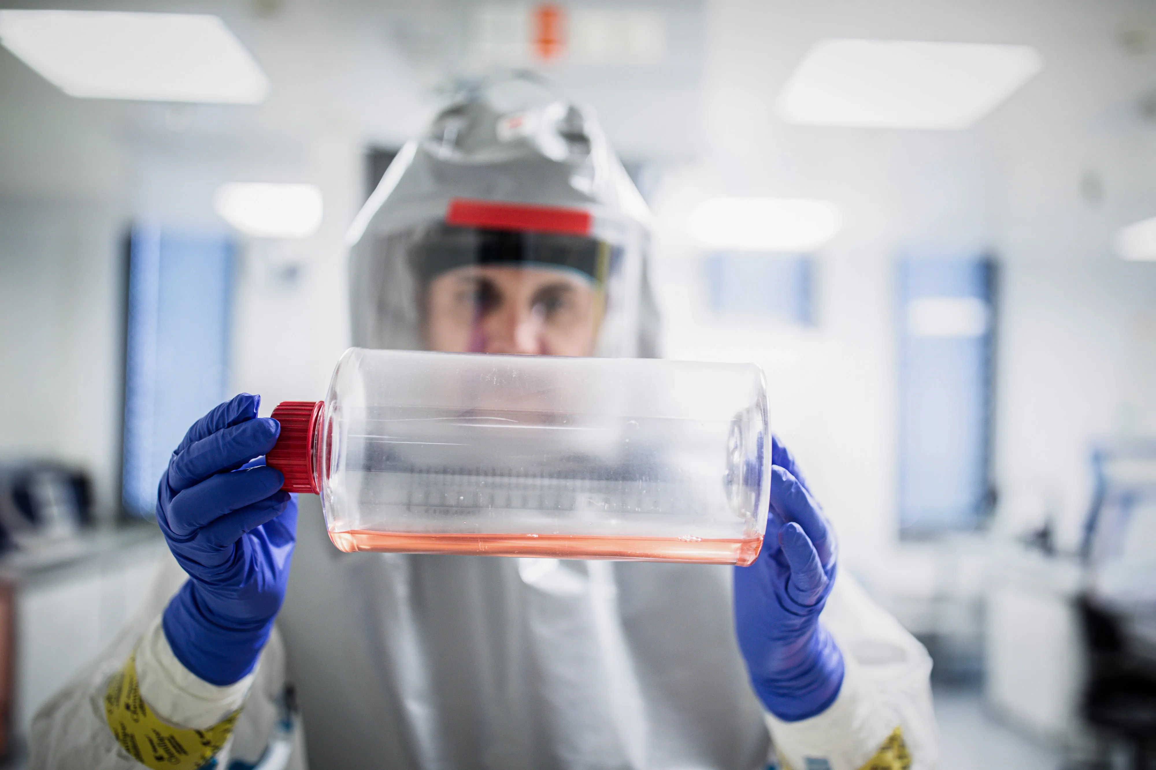 A lab technician&nbsp;inspects a bottle containing growth media for virus production during coronavirus vaccine research at the Valneva&nbsp;laboratories in Vienna in 2020.&nbsp;