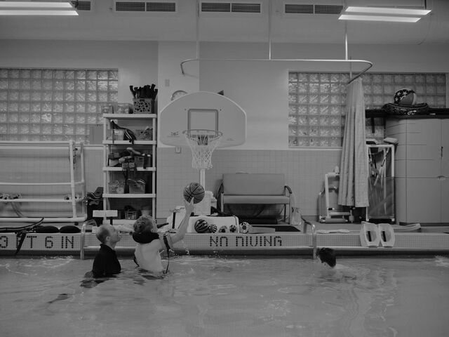 Michael Brewer playing basketball in the rehab facility's pool with a man standing nearby