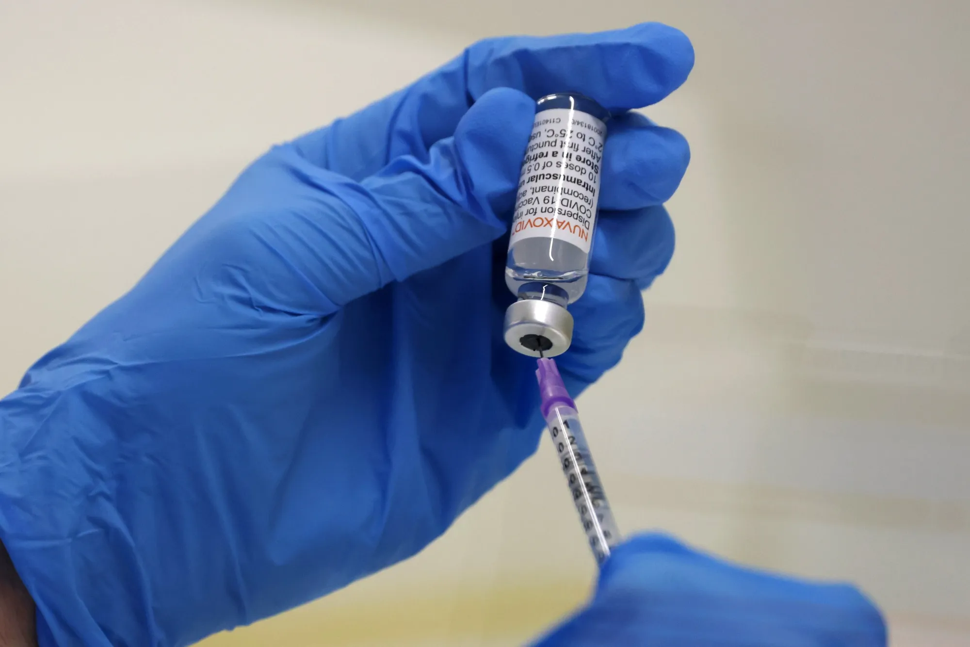 A health-care worker prepares a syringe of the Novavax Covid-19 vaccine.