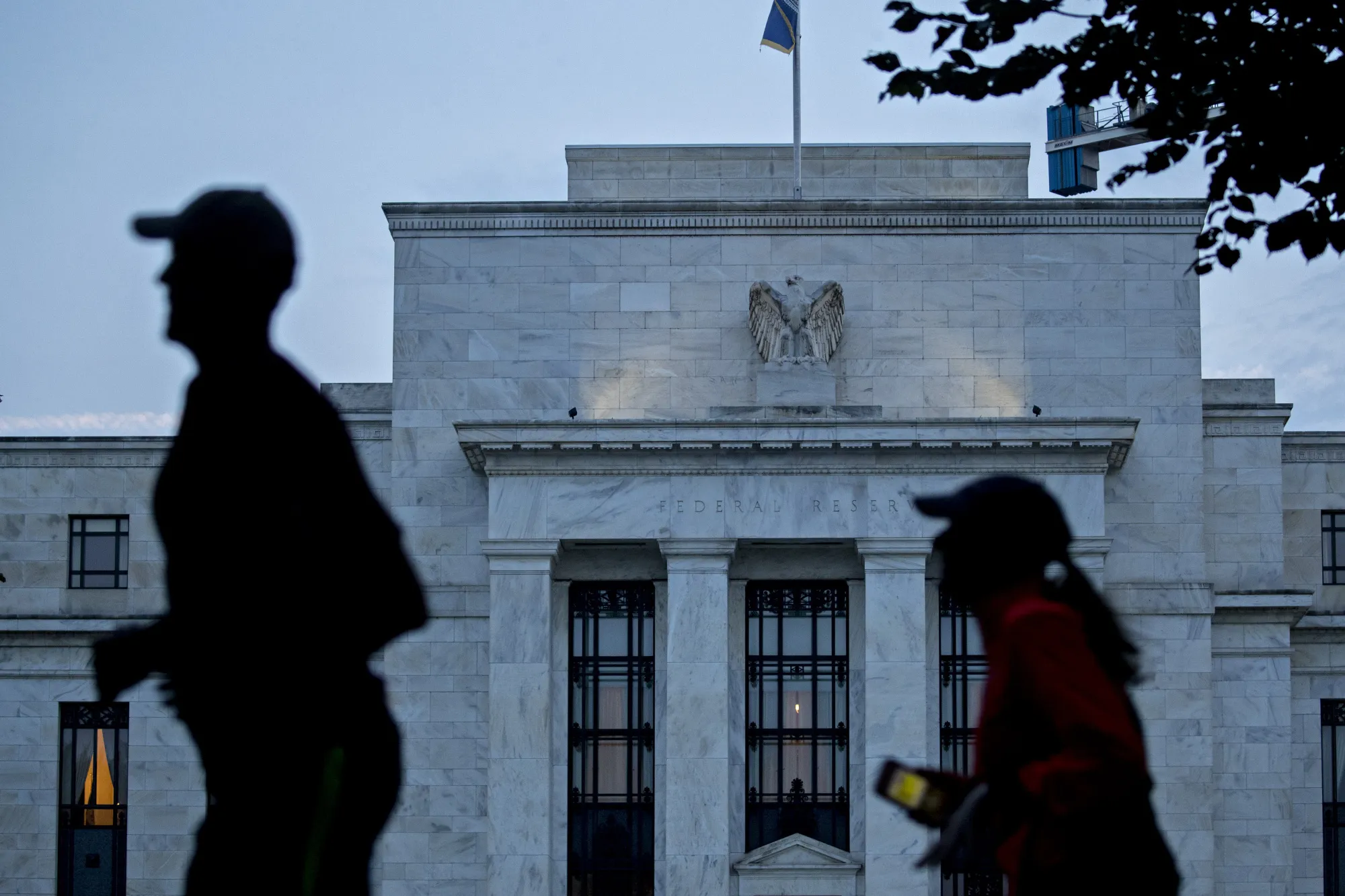 Runners pass the Marriner S. Eccles Federal Reserve building in Washington, D.C.