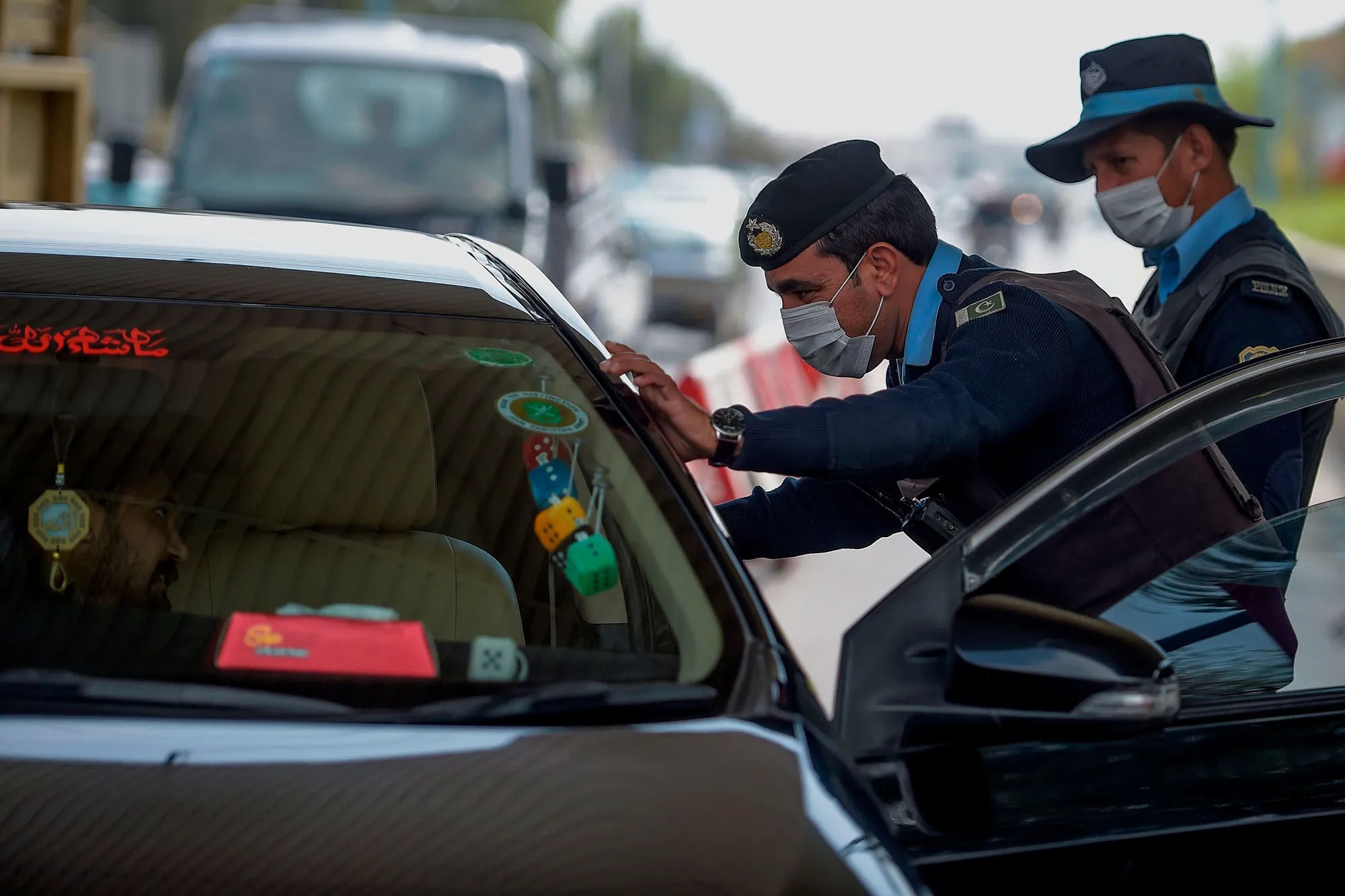 Policemen wearing facemasks check a car at the capital entry&nbsp;checkpoint in Islamabad on March&nbsp;14.&nbsp;