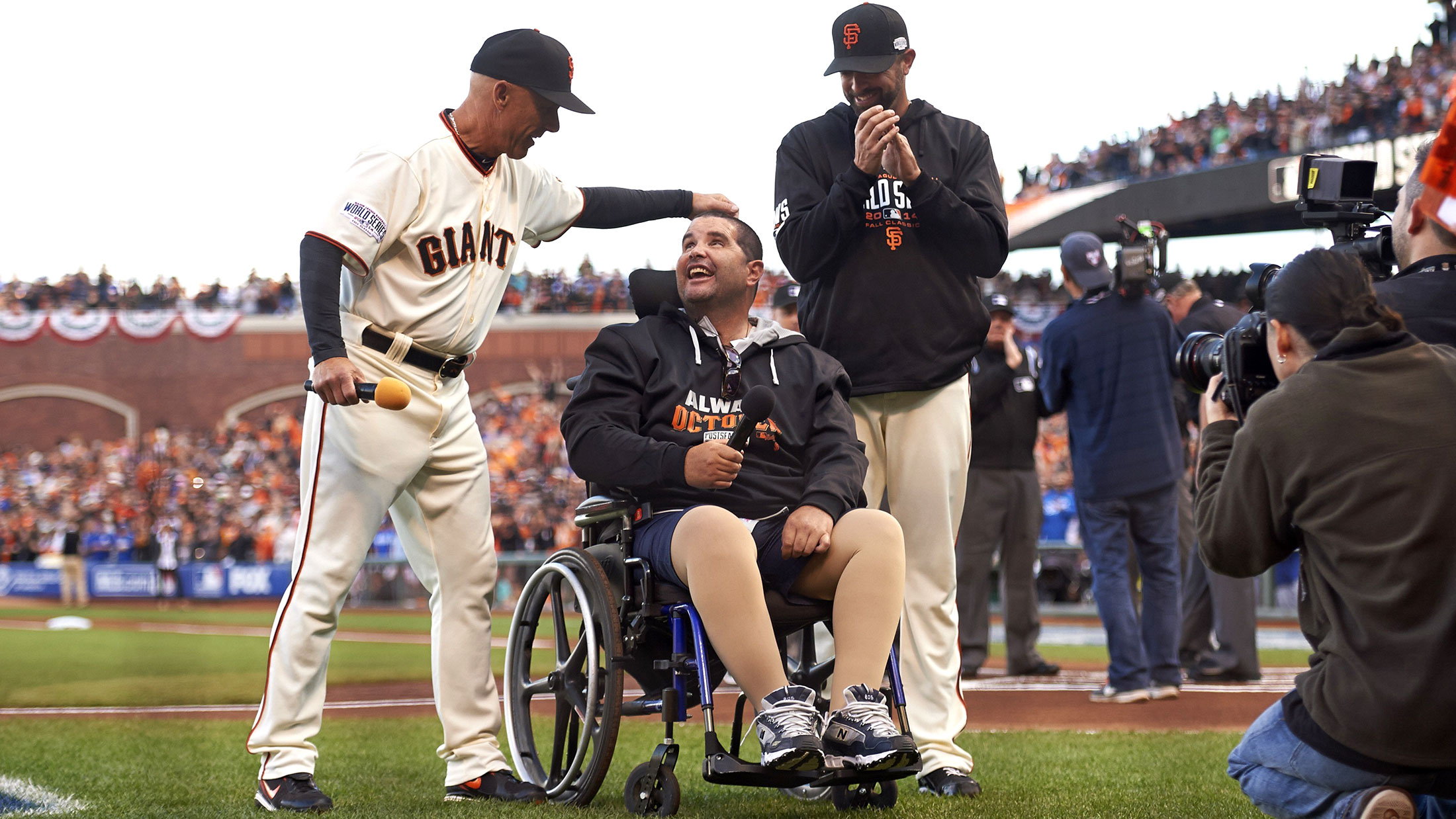 San Francisco Giants fan Bryan Stow, center, before announcing “Play Ball!” with third base coach Tim Flannery and Jeremy Affeldt before a game against the Kansas City Royals at AT&amp;T Park on Oct. 25, 2014.
