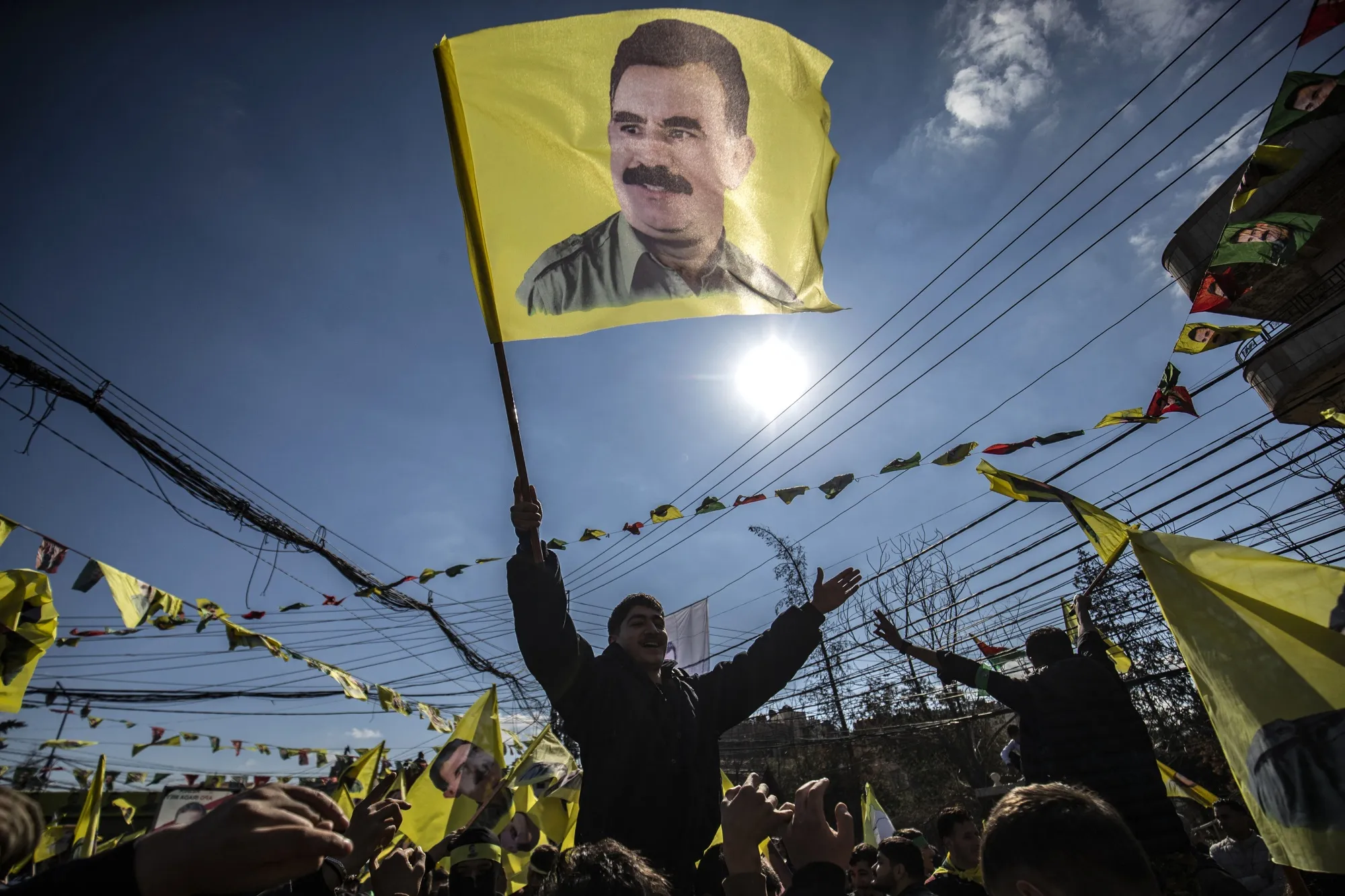 A protester waves a flag bearing a portrait of Abdullah Ocalan, during a demonstration calling for his release, in Qamishli, Syria on Feb. 15.