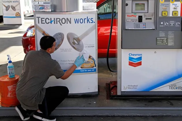 An attendant cleans gas pumps at a Chevron station in downtown Los Angeles in 2012