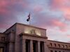 A U.S. flag flies on top of the Marriner S. Eccles Federal Reserve building at sunrise in Washington, D.C.