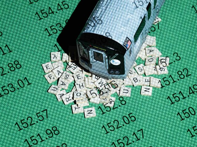 Photograph of a toy subway car on top of scrabble tiles