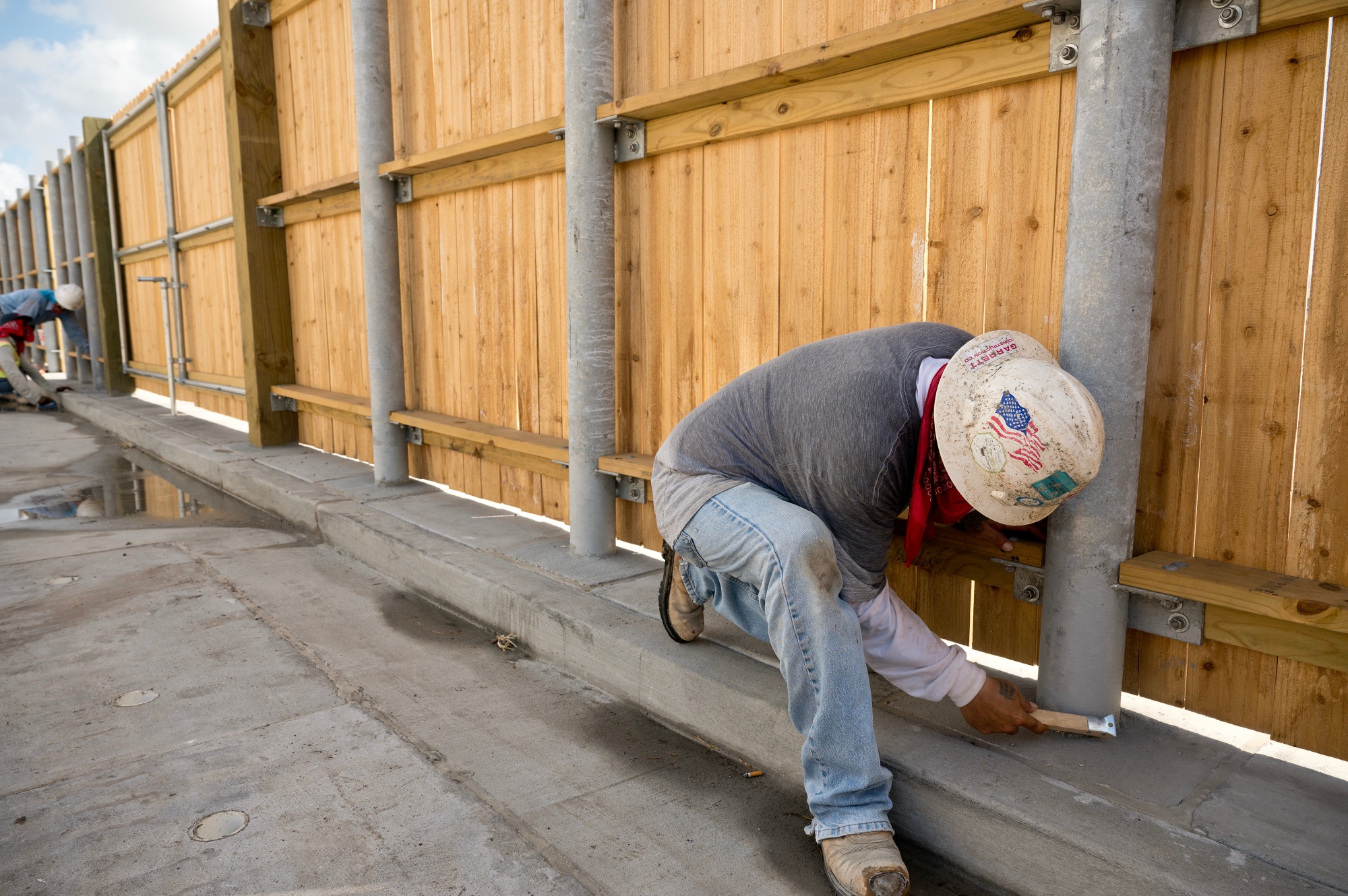 Contractors work on a fence in Corpus Christi, Texas.