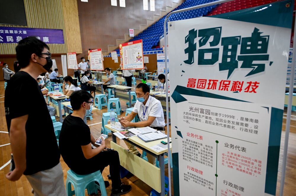 A job seeker talks with a human resource official at a job fair in Zhengzhou, July 2020.