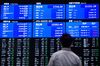 A man looks at screens displaying stock indices at the Tokyo Stock Exchange (TSE), operated by Japan Exchange Group Inc. (JPX), in Tokyo, Japan, on Friday, Feb. 9, 2018. The Topix index headed for its worst week in two years following a meltdown in U.S. equities amid concern rising interest rates will damp economic growth.