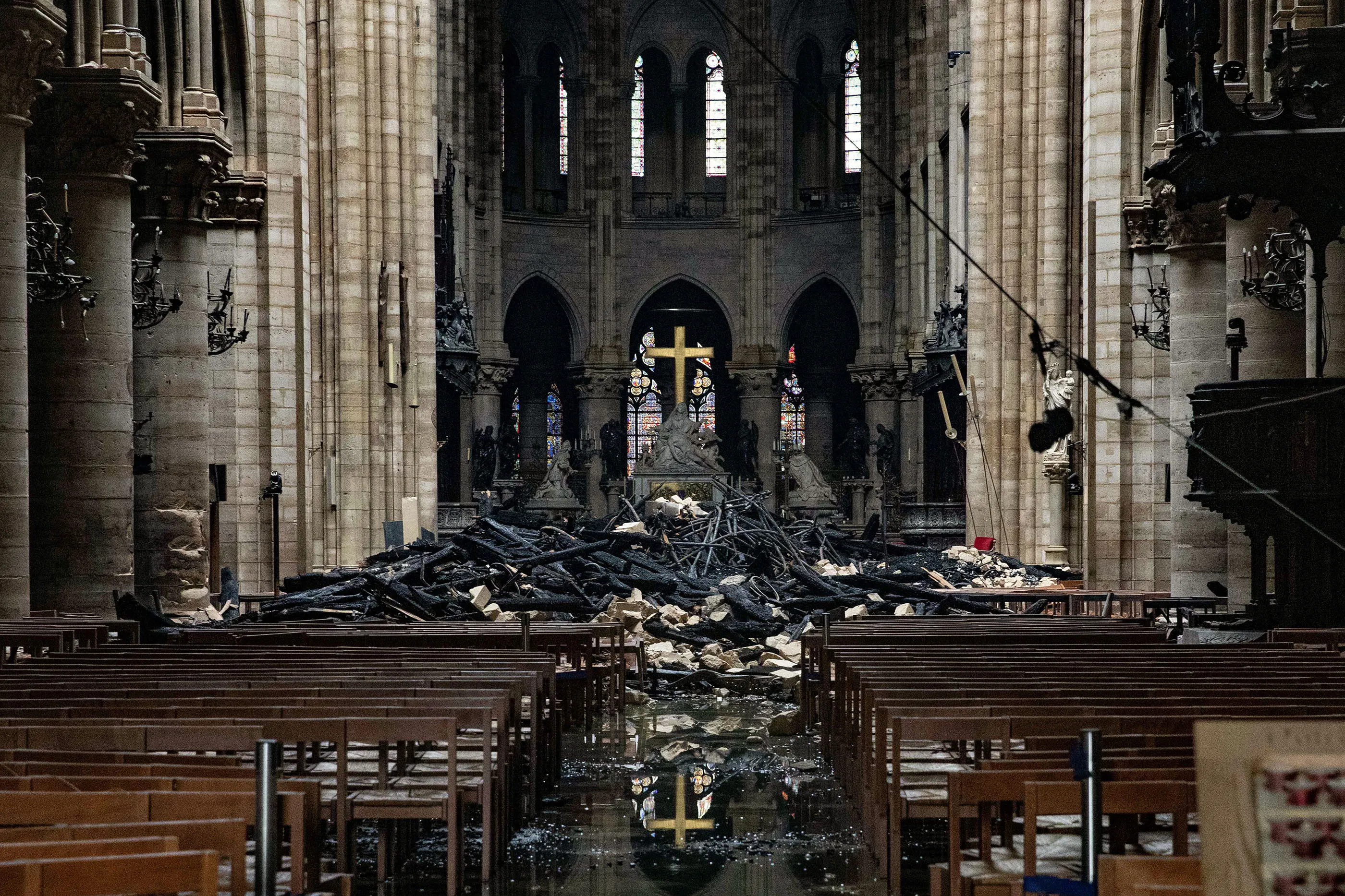 Fire damaged wood and stone sits near the altar inside Notre Dame Cathedral in Paris, France, on Tuesday, April 16, 2019. Authorities declared Tuesday morning that the blaze had been contained as firefighters hosed the south side of the transept to cool down the building, and a district around the cathedral was sealed as military and police patrolled the area.