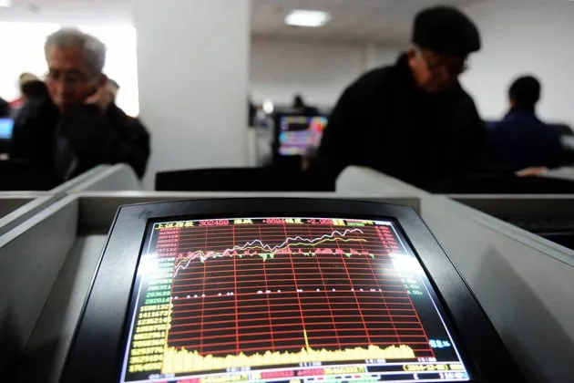 Investors check the share prices at a security firm in Qingdao, China