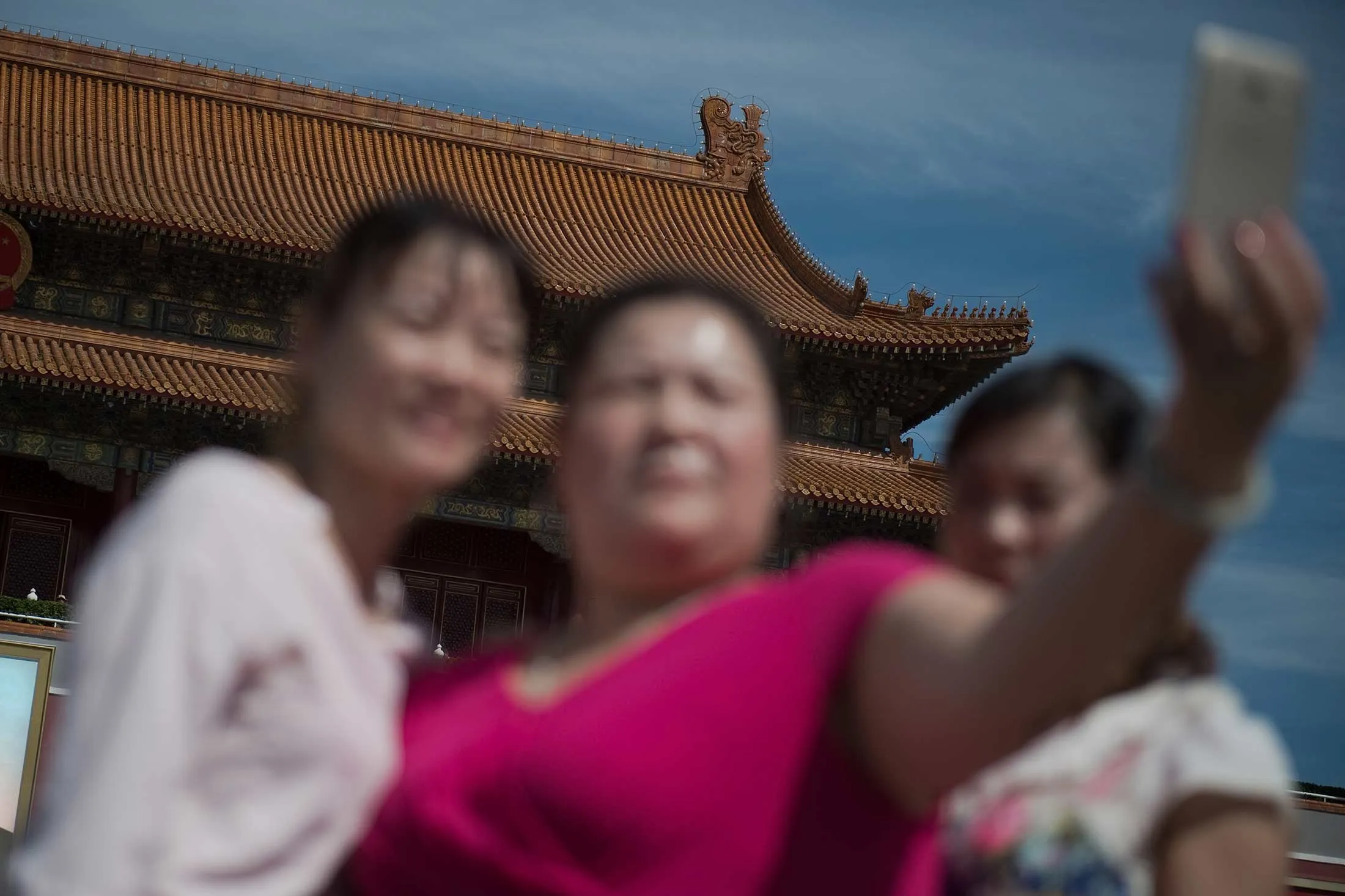 People take a selfie with a smartphone&nbsp;at the gate of the Forbidden City in Beijing.