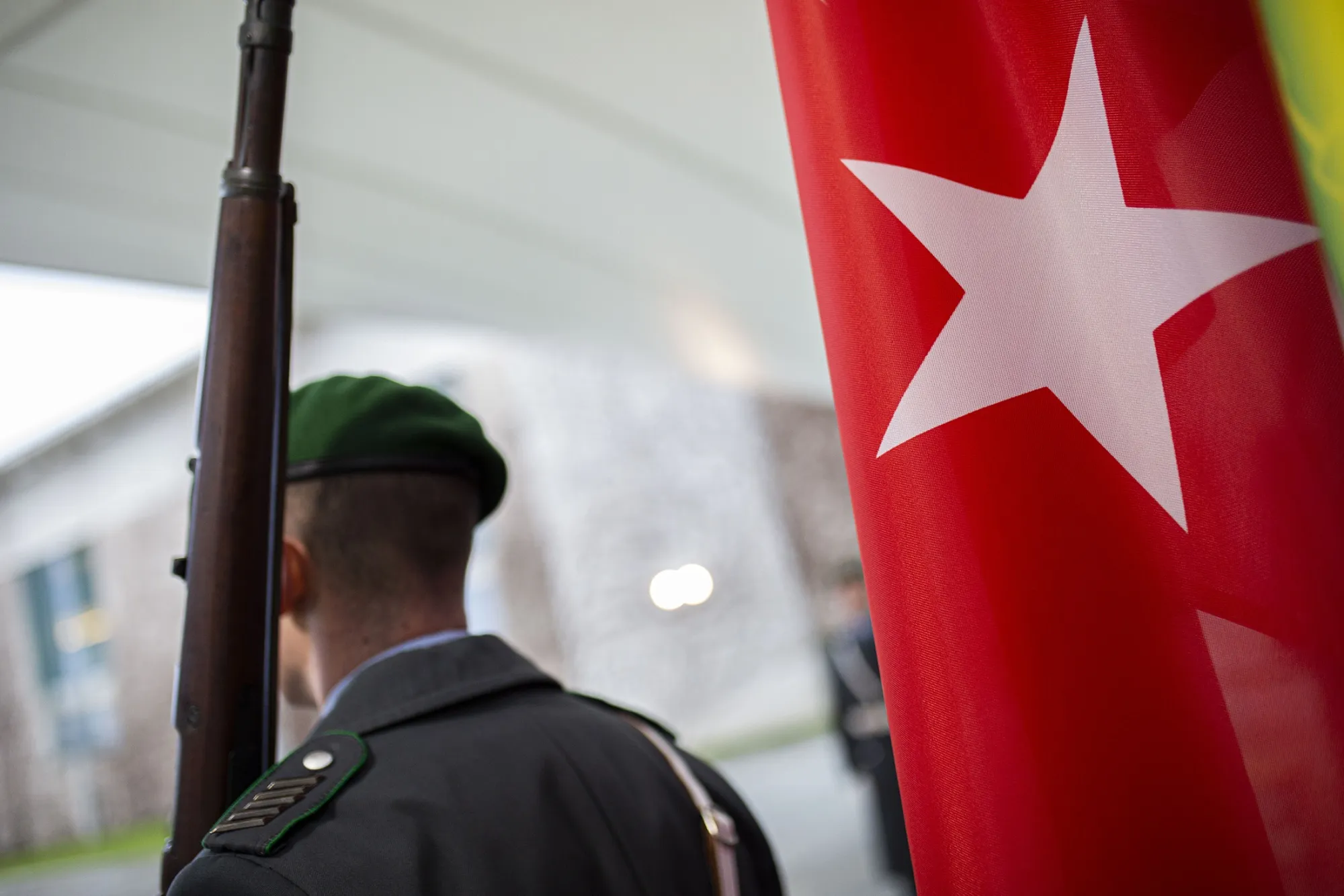 A soldier stands next to&nbsp;the Turkish flag.
