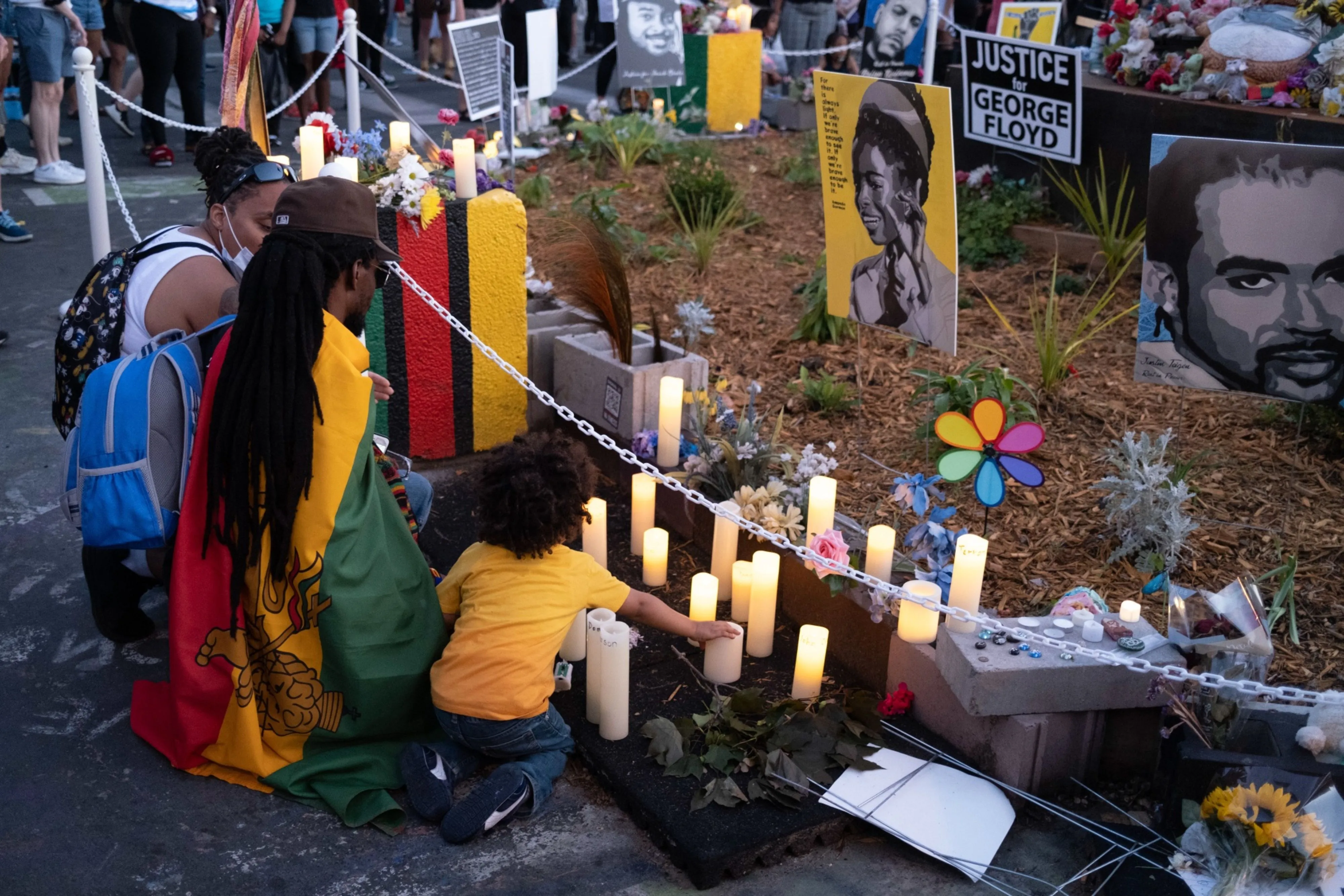 People kneel in front of candles during a vigil for George Floyd in Minneapolis on May 25, 2021. Floyd’s death might not have been captured as police violence under official methods of counting.&nbsp;