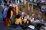 People kneel in front of candles during a vigil for George Floyd in Minneapolis on May 25, 2021. Floyd’s death might not have been captured as police violence under official methods of counting. 