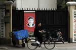 A cyclist rides past a banner depicting Chinese President Xi Jinping in Shanghai, China.