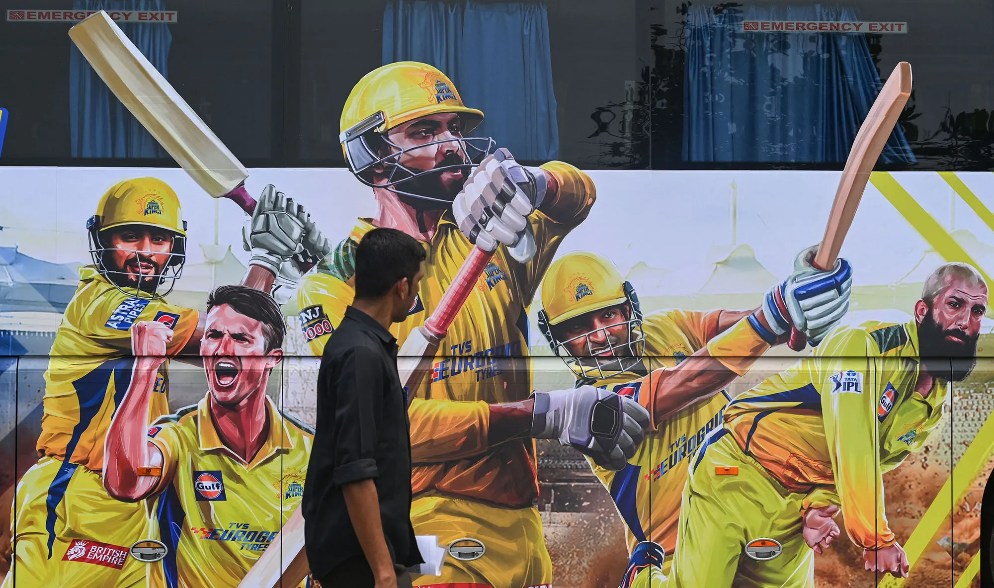 A pedestrian walks past the bus of Indian Premier League's Chennai Super Kings in Mumbai.