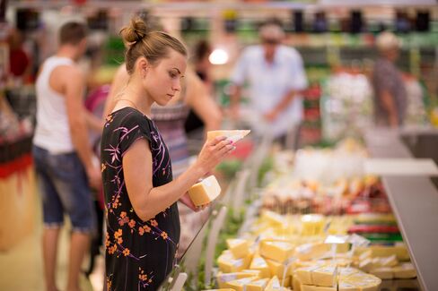 A customer checks the prices of slices of cheese inside an OAO Magnit hypermarket in Krasnodar, Russia, on Thursday, Aug. 7, 2014.