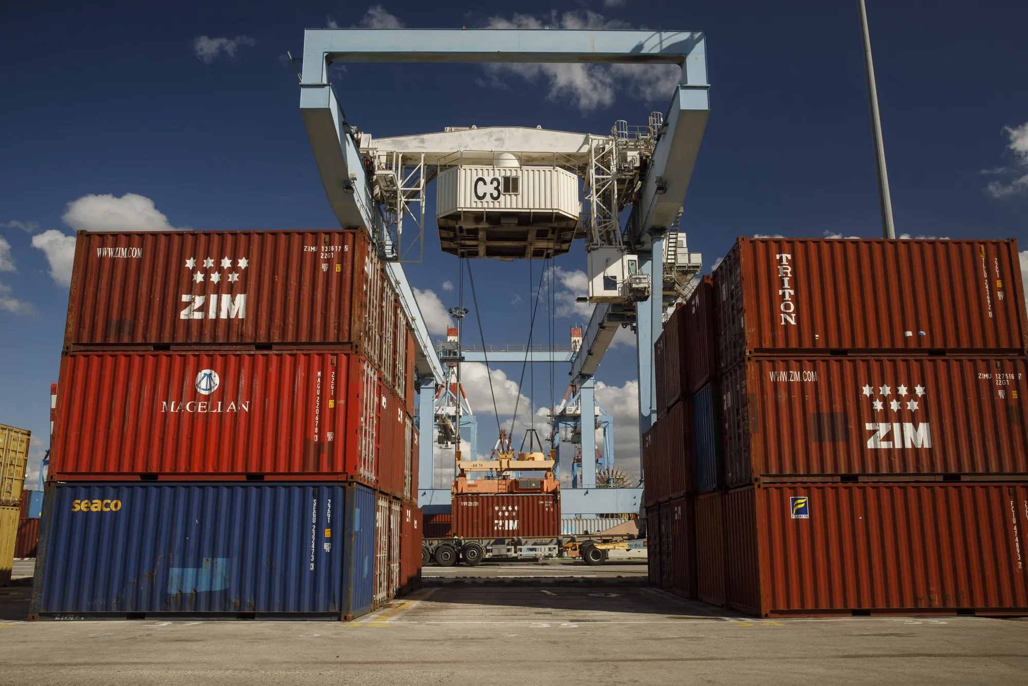 A crane lifts a ZIM Integrated Shipping Services Ltd. branded shipping container dockside at the Port of Haifa in Haifa, Israel.