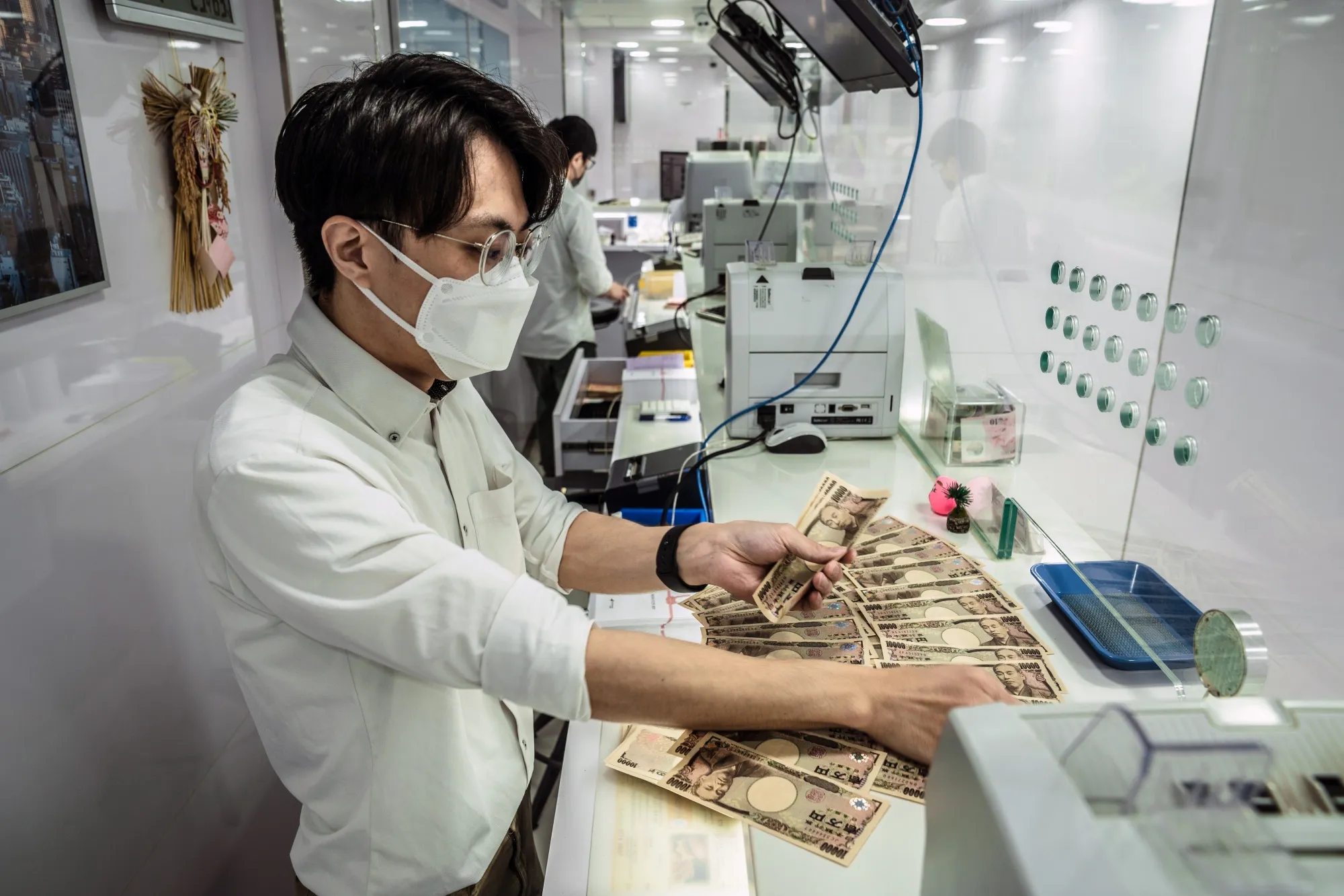 An employee counts Japanese 10,000 yen banknotes at the Birdy Exchange in Hong Kong, on June 16. 