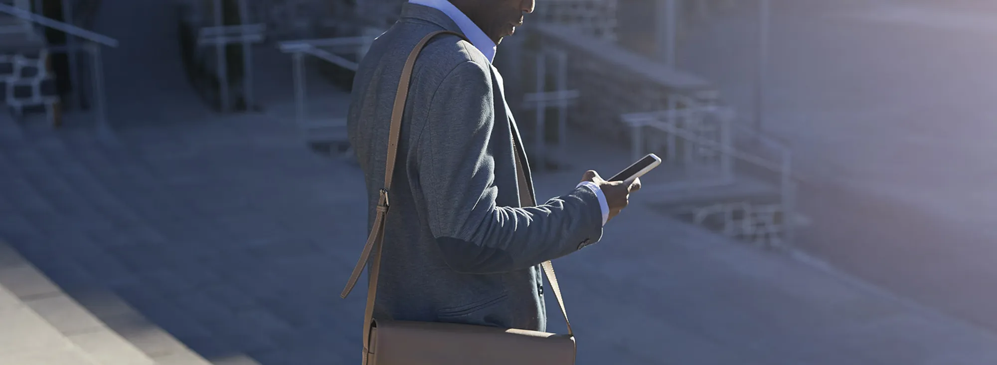 Businessman walking on with bags, outside at sunrise