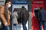 Customers use automatic teller machines in Istanbul.