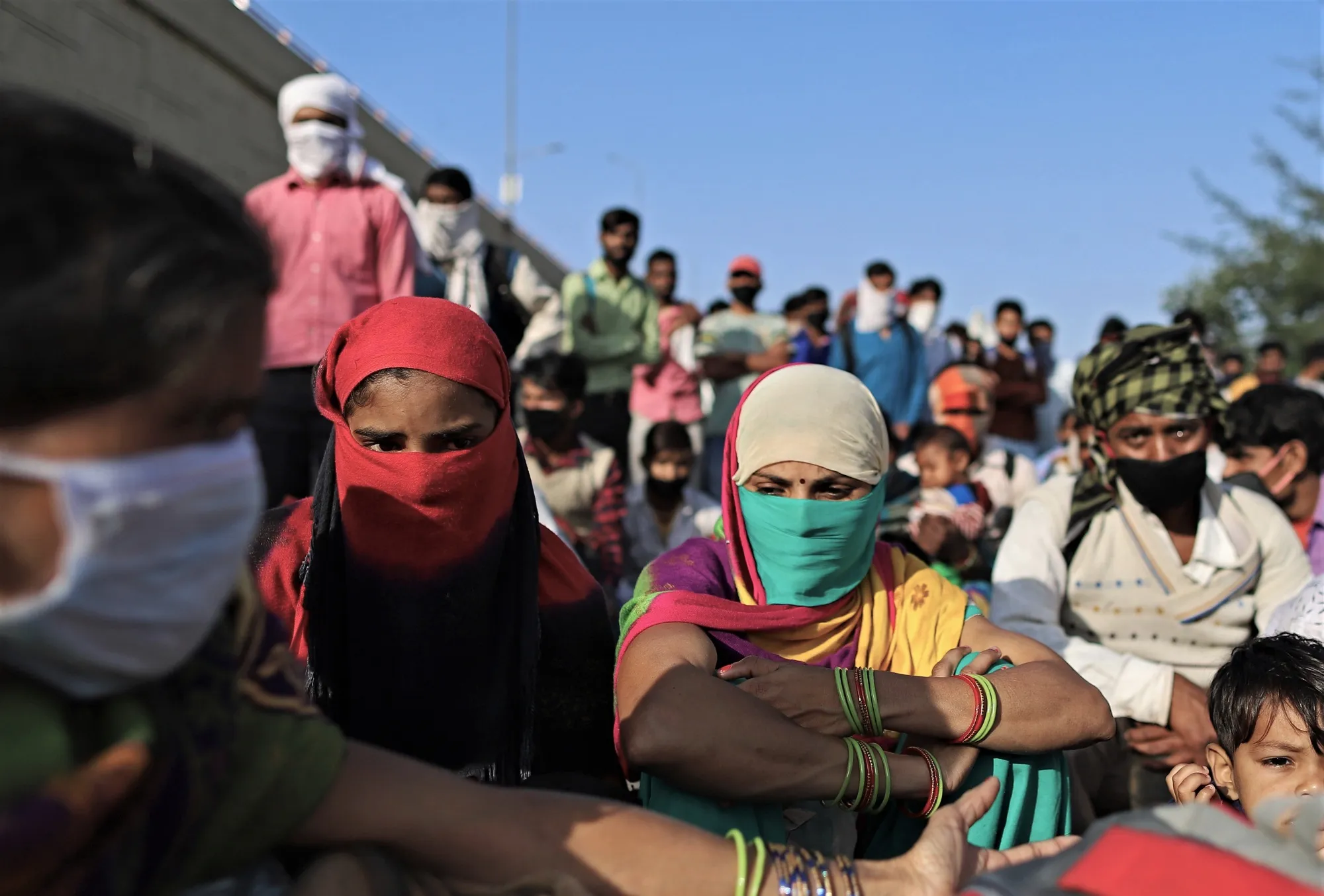 Migrant workers and their families gather at a checkpoint during a government lockdown in New Delhi, March 2020.