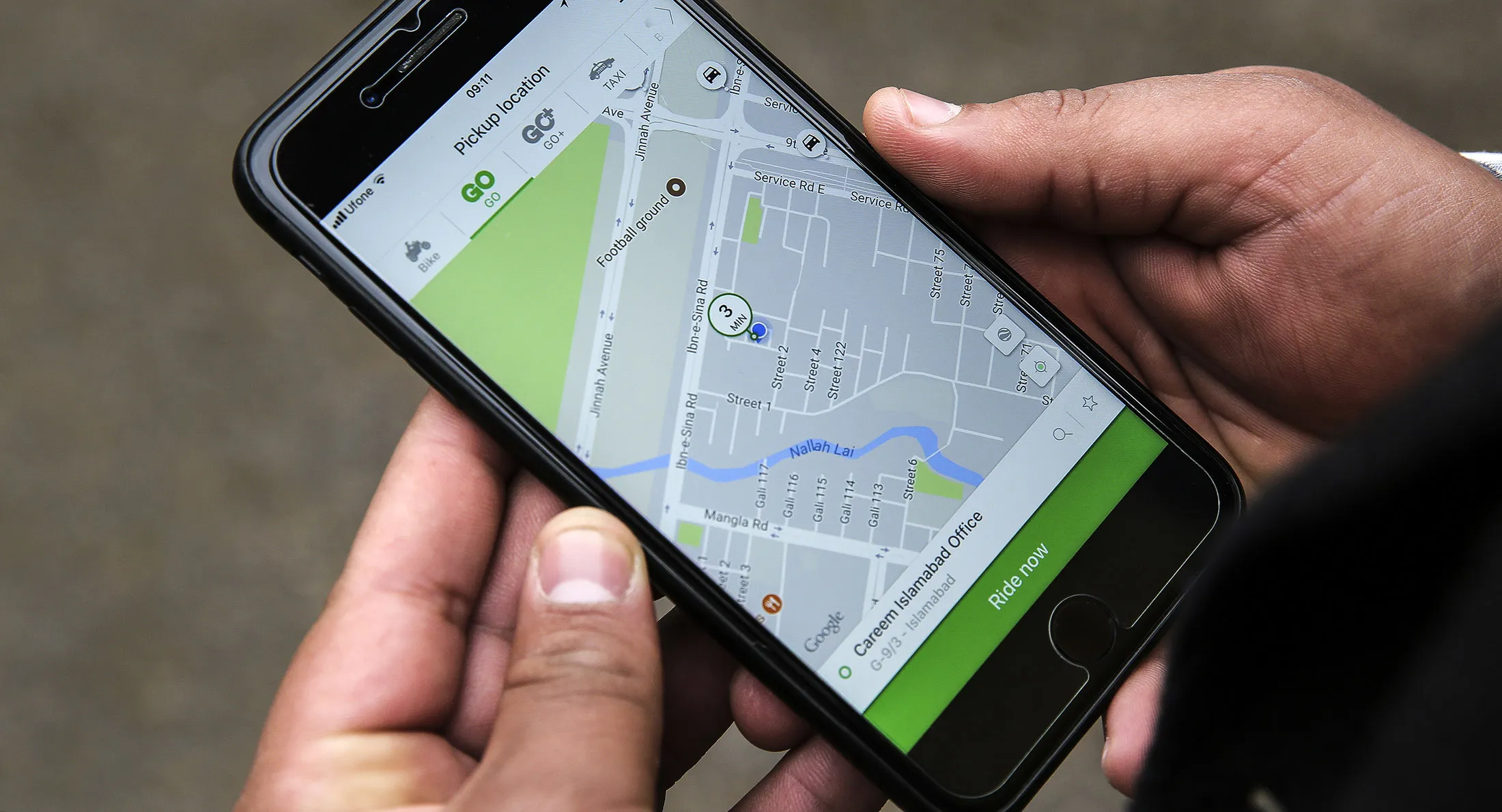 A person&nbsp;displays the Careem ride-hailing app while booking a car in this arranged photograph in Islamabad, Pakistan.