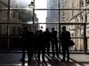 Commuters stand silhouetted against the window as they wait for a Docklands Light Railway (DLR) train.