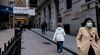 A pedestrian wearing a protective mask walks past the New York Stock Exchange.