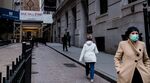 A pedestrian wearing a protective mask walks past the New York Stock Exchange.