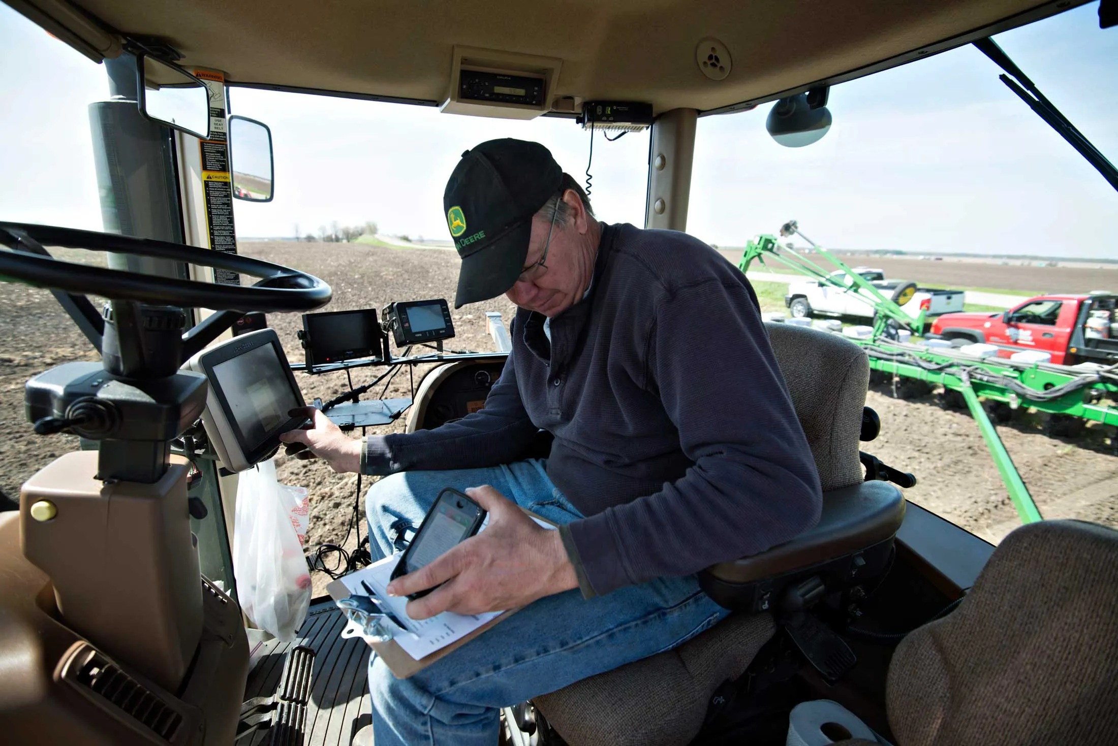 Farmer Kent Bickett loads seed variety codes into a computer on a John Deere tractor in Malden, Ill., in May 2014.
