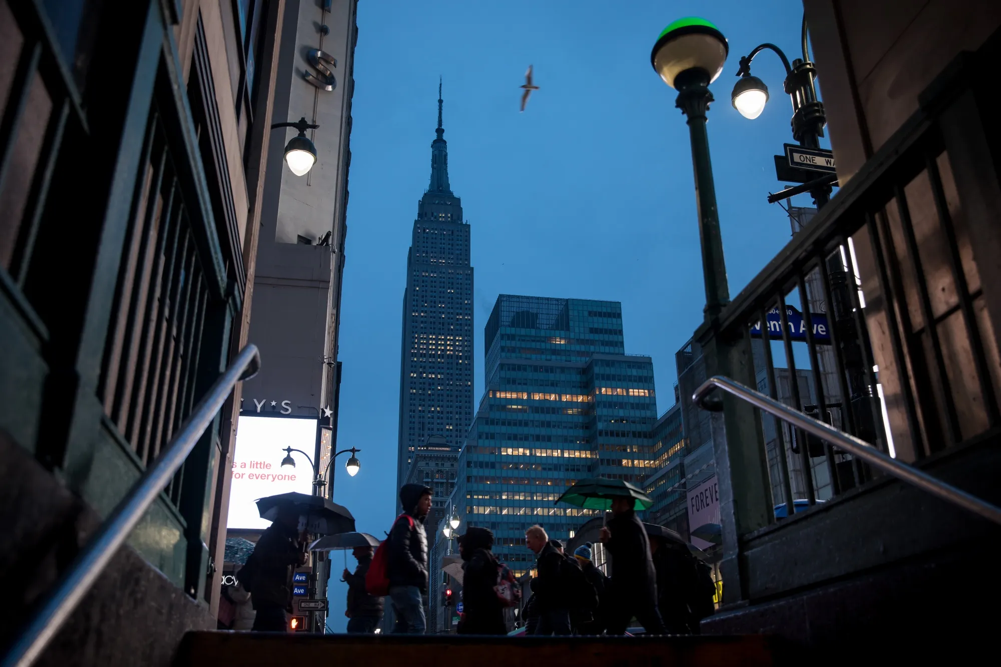 Pedestrians pass in front of the Empire State Building in New York.