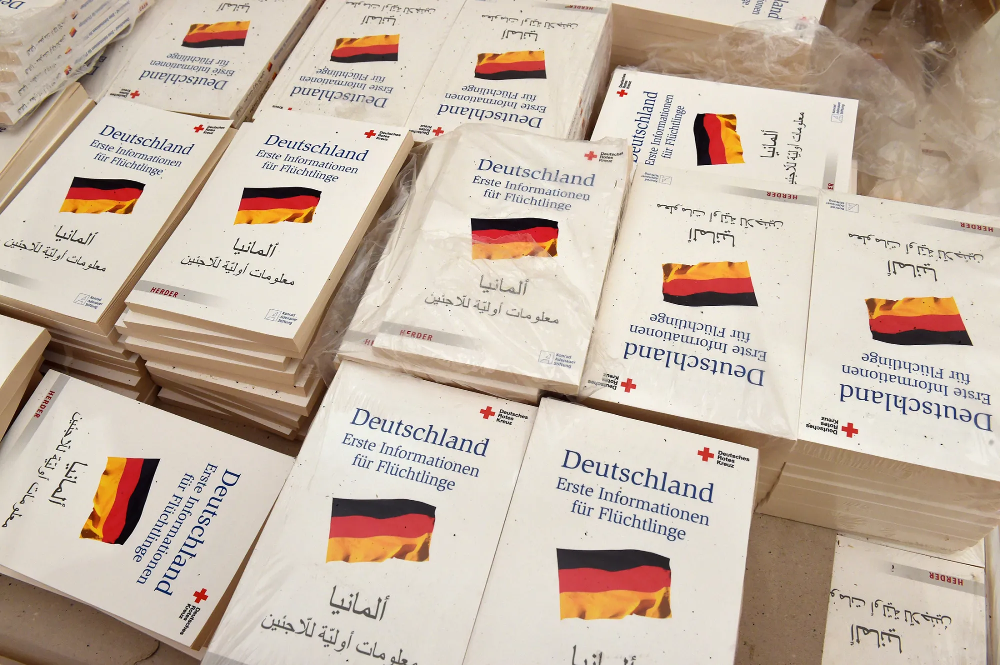 Books with the title 'first information for refugees' lie in a welcoming tent at a registration point for asylum seekers in Erding near Munich.
