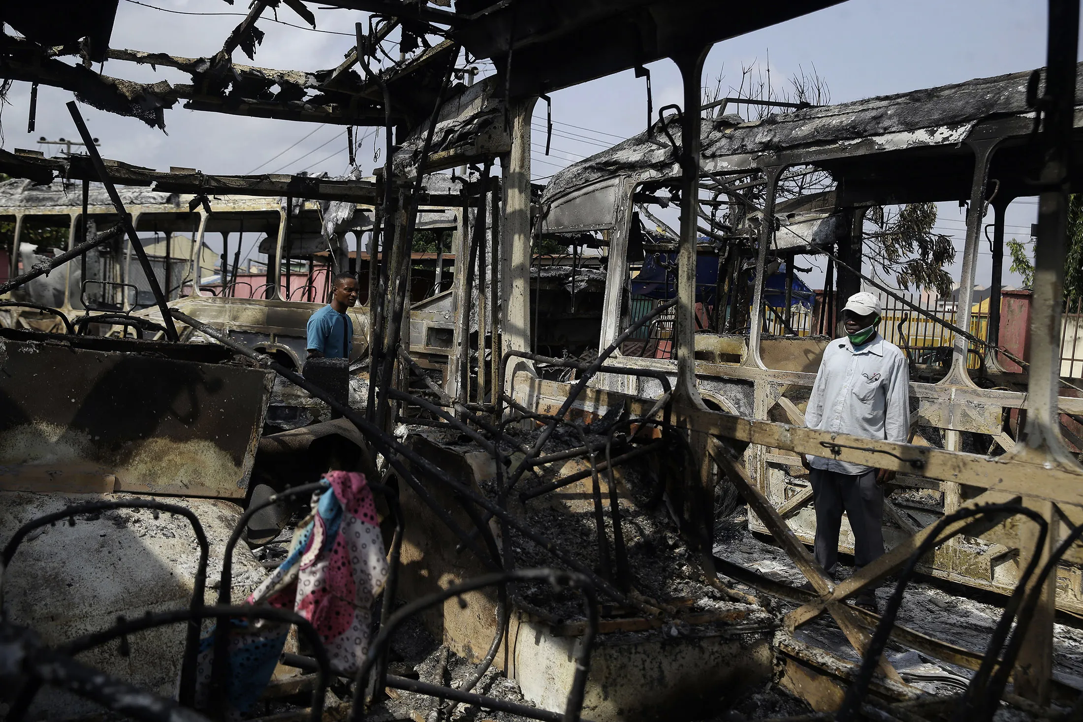 People look at burnout buses in Lagos on Oct. 24.&nbsp;