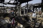 People look at burnout buses in Lagos on Oct. 24.