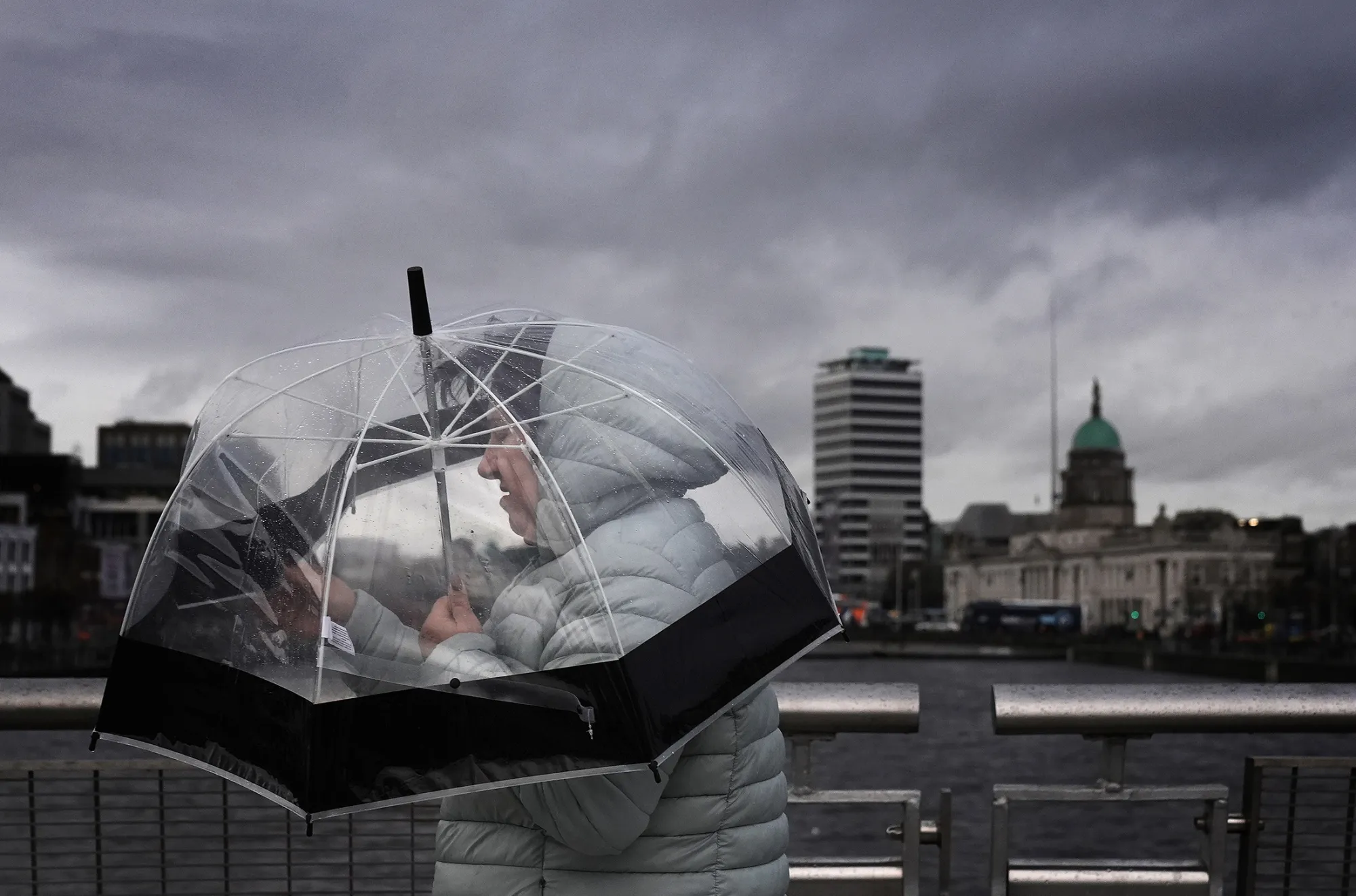 A person takes shelter under an umbrella in Dublin's city centre on Dec. 6.&nbsp;