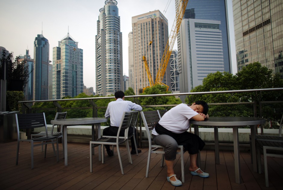 A waitress sleeps as she take a break at a restaurant located in the Pudong financial district of Shanghai in 2013.