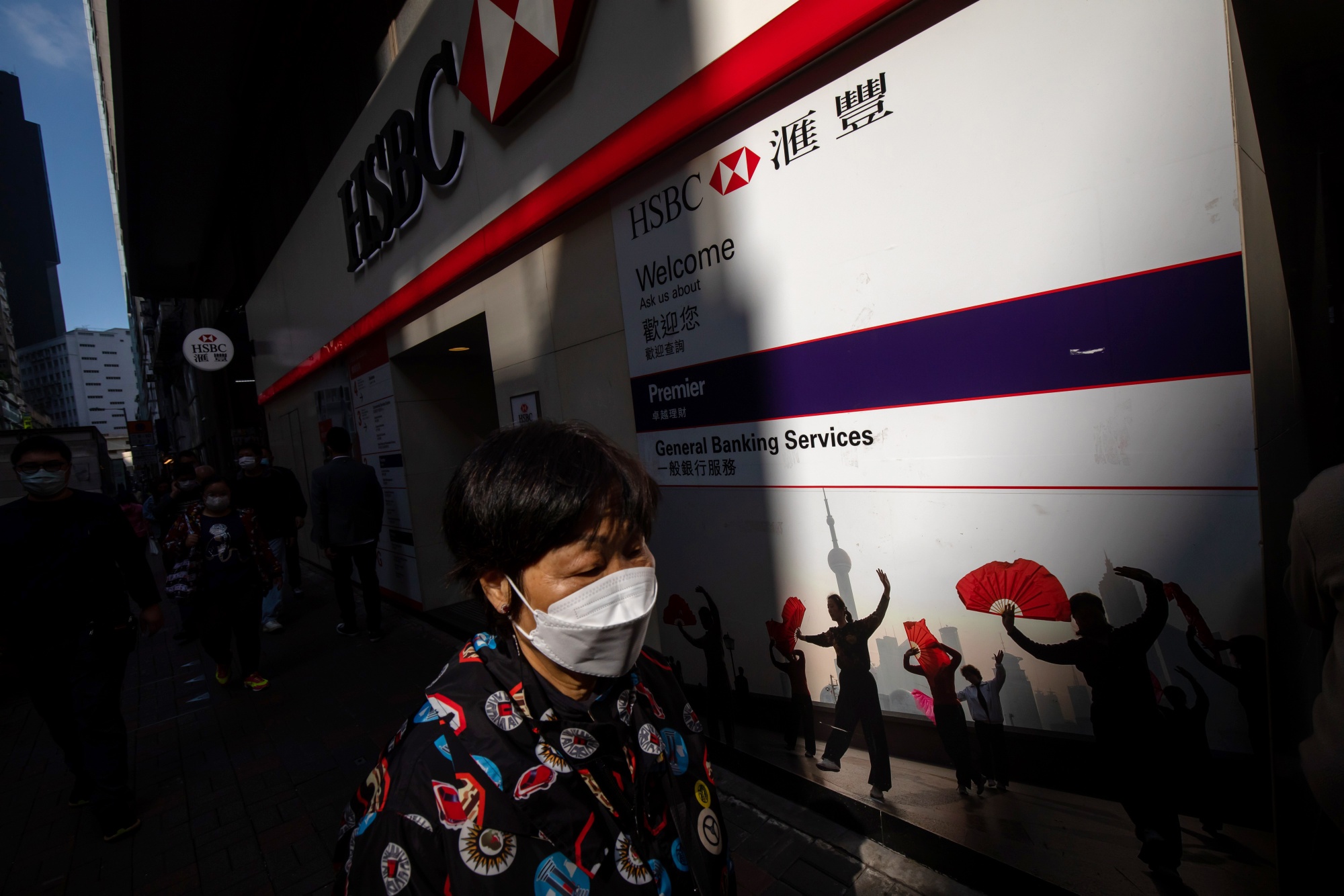 A pedestrian wearing a protective face mask walks past an HSBC Holdings Plc bank branch in Hong Kong, China, on Thursday, Dec. 8, 2022.&nbsp;